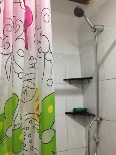 una tenda da doccia in un bagno accanto a un soffione a rose; di Asiriq Wasi Guest House a Cuzco