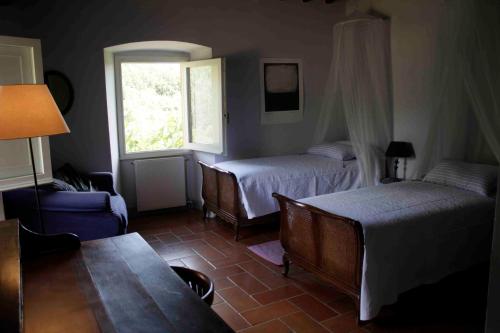 1 dormitorio con 2 camas y ventana en Le Tre Colombe, en Bagno a Ripoli