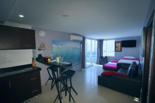 a kitchen and living room with a table and a bed at Apartamentos Bacanos in Cartagena de Indias