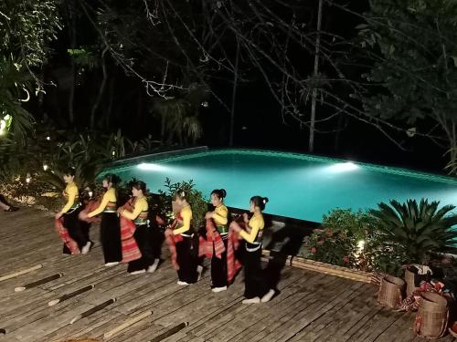 a group of women dancing in front of a pool at night at Puluong Home in Pu Luong