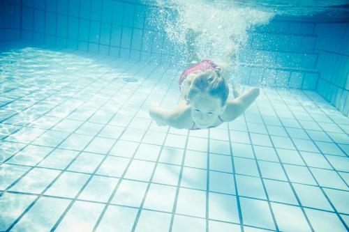 a young child swimming in a swimming pool at Du Lac Et Du Parc Grand Resort in Riva del Garda