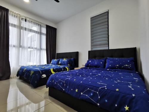 a bedroom with two beds with blue comforters and stars at Thermospace Atlantis C-34-08 Melaka City in Melaka