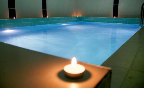 a candle in front of a swimming pool with a lit candle at Adanava Hotel in Adana