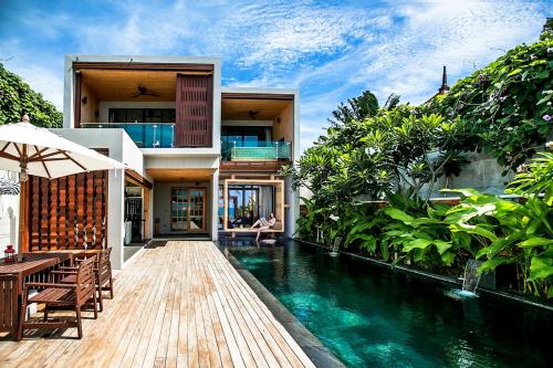 a house with a swimming pool in front of a house at Pavilion Samui Villas and Resort - SHA Extra Plus in Lamai