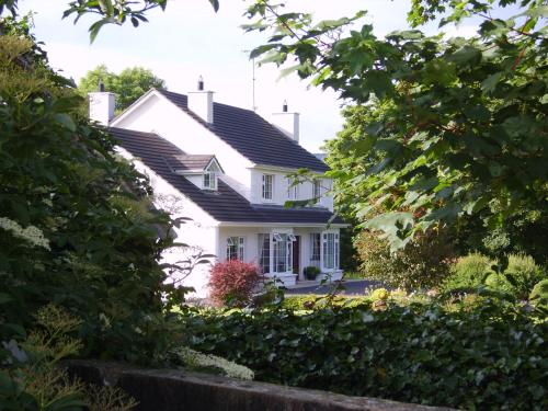 uma casa branca com um telhado preto em Lake Avenue House em Ballyconnell