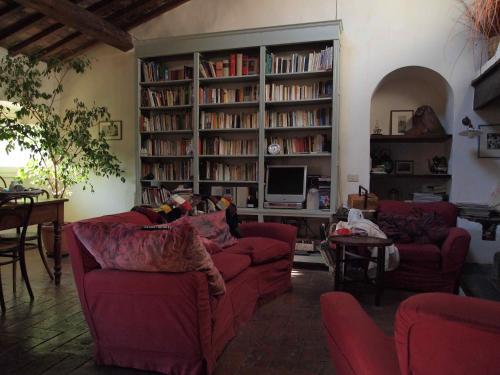 sala de estar con sofás rojos y TV en Le Tre Colombe, en Bagno a Ripoli