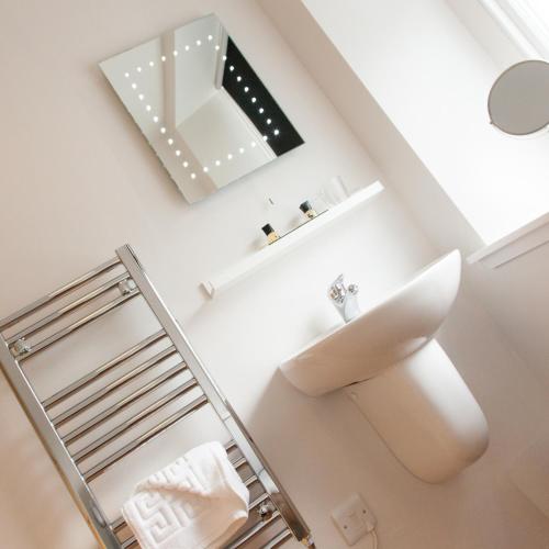 a bathroom with a mirror and a sink at The Salmon Inn in Galashiels