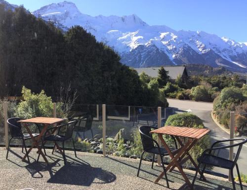 two tables and chairs on a balcony with mountains at Aoraki Mount Cook Alpine Lodge in Mount Cook Village