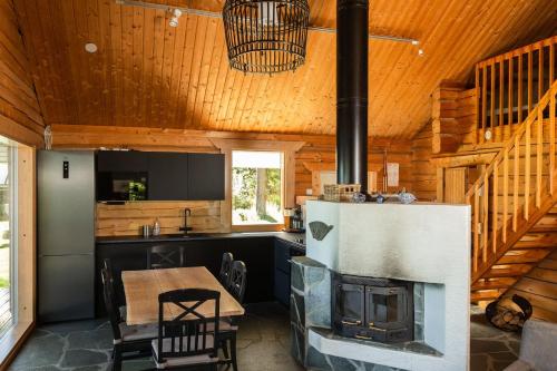 a kitchen and dining room with a fireplace in a log cabin at Kalaranta Cottage in Muurame