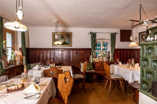 ein Esszimmer mit Tischen, Stühlen und Holzwänden in der Unterkunft Landgasthof & Restaurant Batzenhäusl in Sankt Gilgen