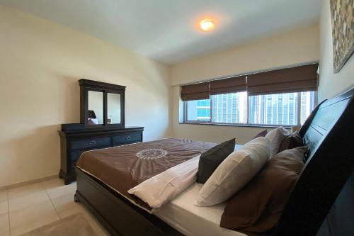 a bedroom with a bed with a dresser and a window at OYO 586 Home 1206 East Heights 3, Executive Towers in Dubai