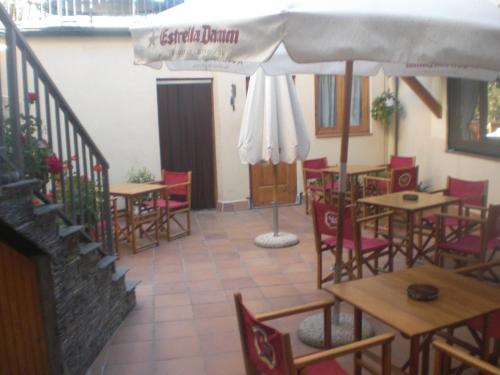 a restaurant with tables and chairs and an umbrella at Roch Hotel in Altrón