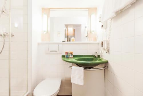 a bathroom with a green sink and a toilet at Ibis Graz in Graz