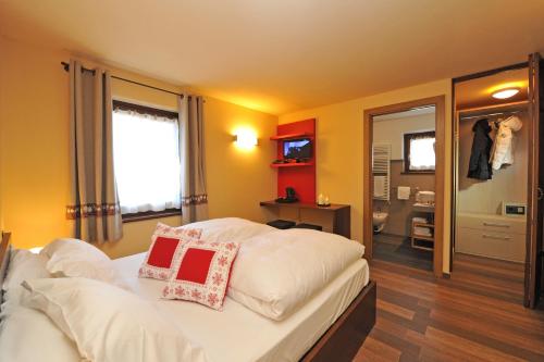 1 dormitorio con 1 cama blanca y 2 almohadas en Hosquet Lodge, en Breuil-Cervinia