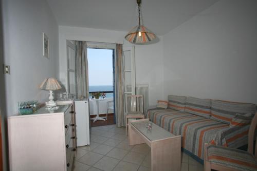 a living room with a couch and a table at Lemos Hotel in Kokkari