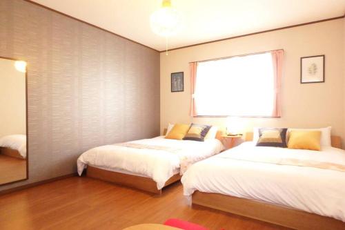 1 Schlafzimmer mit 2 Betten und einem Fenster in der Unterkunft Fukenouchi House in Kyoto