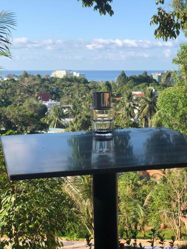 a glass on a table with a view of the ocean at BIỂN ĐỒI Bungalow in Phu Quoc