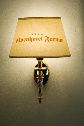 a lamp with an antiquated seruman on a wall at Alpenhotel Fernau in Neustift im Stubaital
