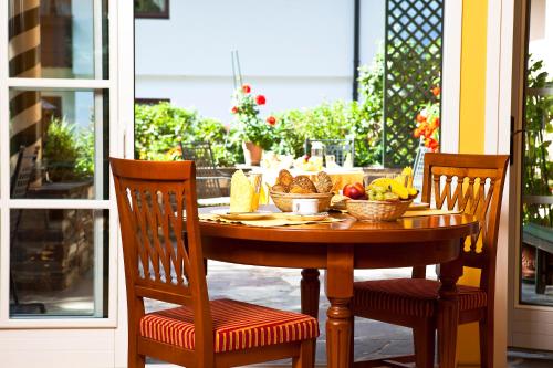 a wooden table with bowls of fruit on a porch at Aparthotel Landhaus St. Joseph (Indoor Pool) in Mayrhofen