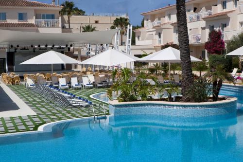a pool at a resort with chairs and umbrellas at Aparthotel Isla de Cabrera in Colonia Sant Jordi