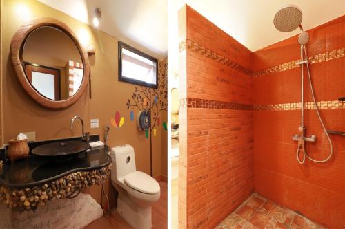 a bathroom with a toilet and a sink and a mirror at Is Am O Chiang Mai Resort in San Sai