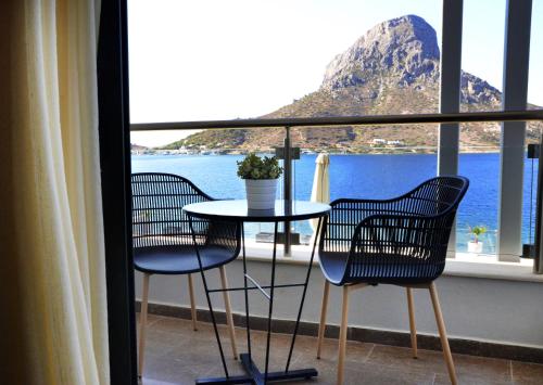 a table and chairs on a balcony with a view of the ocean at MASSOURI BEACH HOTEL in Masouri