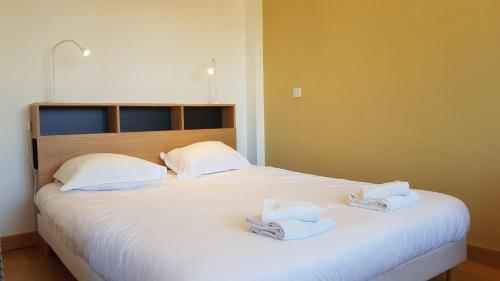 sypialnia z dużym białym łóżkiem z ręcznikami w obiekcie Little Suite - Marceau w Lille