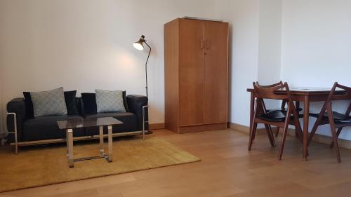 un salon avec un canapé et une table dans l'établissement Little Suite - Marceau, à Lille