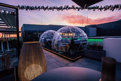 two bubble domes on a rooftop with a sunset at INNSiDE by Meliá Leipzig in Leipzig