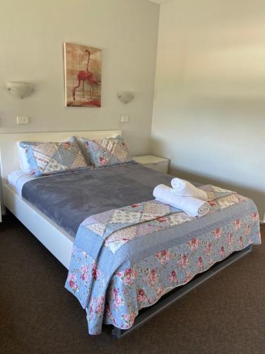 a bed in a bedroom with a white bedspread at Ettalong Beach motel in Ettalong Beach