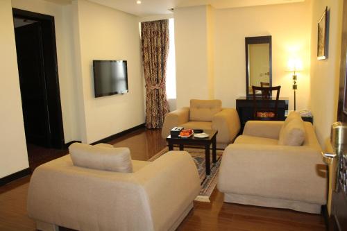 a living room with two couches and a tv at Ramada by Wyndham Islamabad in Islamabad