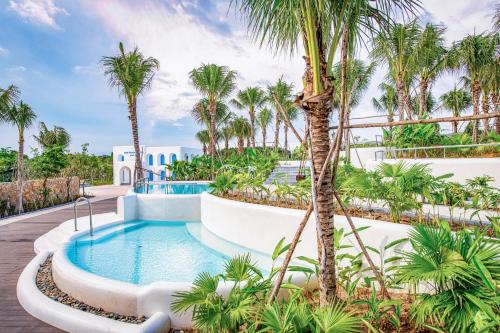 a pool at a resort with palm trees at Minera Hot Springs Binh Chau in Binh Chau