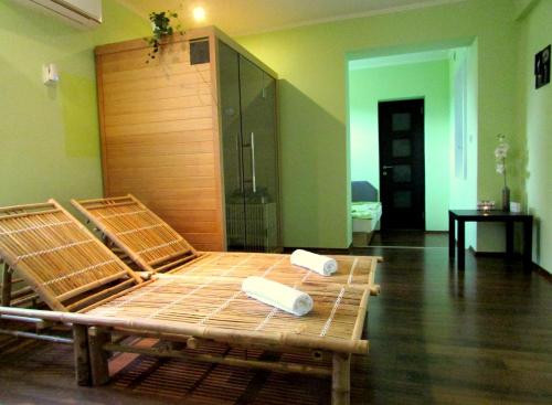 a bed in a room with two towels on it at Green Corner Wellness in Püspökladány