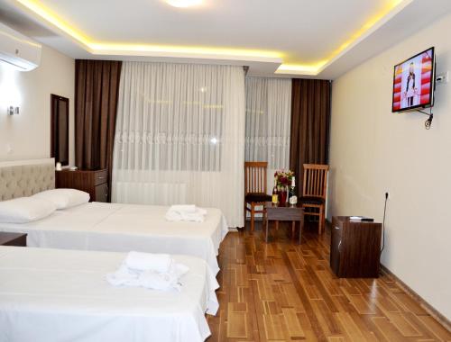 una camera d'albergo con due letti e una TV di Hotel Grand Mark a Istanbul