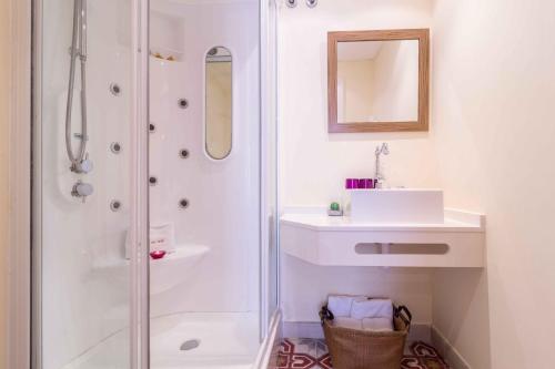 a white bathroom with a shower and a sink at Residencial Terra de Mar Calpe, Grupo Terra de Mar, alojamientos con encanto in Calpe