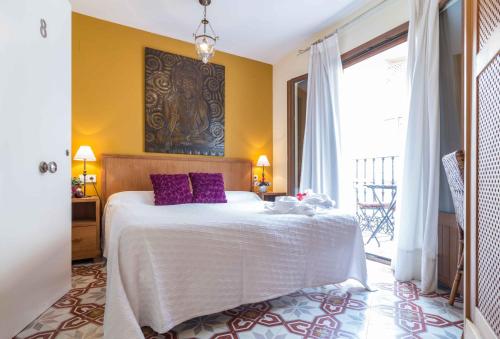 a bedroom with a large bed with purple pillows at Residencial Terra de Mar Calpe, Grupo Terra de Mar, alojamientos con encanto in Calpe
