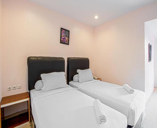 two beds sitting next to each other in a room at Dna Fun Zone Pekanbaru in Pekanbaru