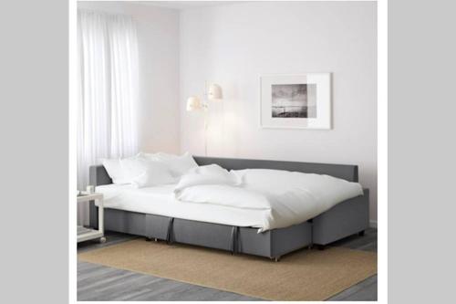 een bed met witte lakens en kussens in een kamer bij The Holmé in Leicester