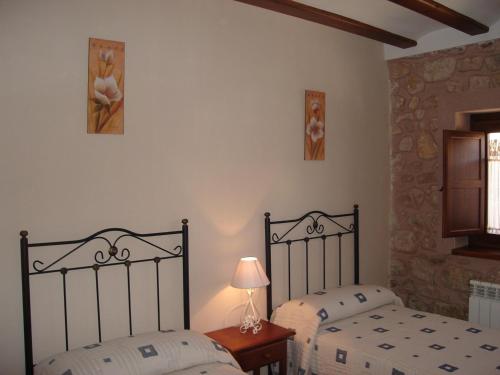 a bedroom with two beds and a lamp on a table at La Insula de Castilnuevo in Castilnuevo