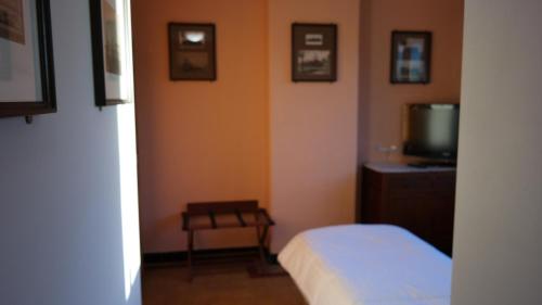 a bedroom with a bed and a tv and a table at De Bonte Os Hotel & Tower in Roeselare