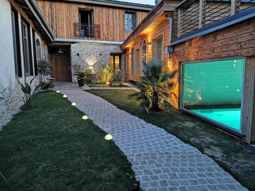 a backyard with a stone walkway next to a house at Logis Hotel Nature Cathare in Léran