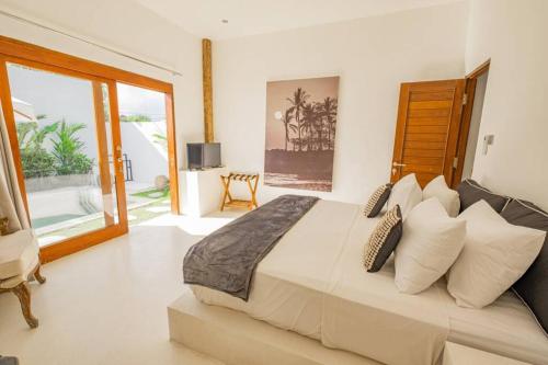ein großes Schlafzimmer mit einem großen Bett mit Kissen in der Unterkunft Luxury 2 bedrooms villa Putih Pererenan in Canggu