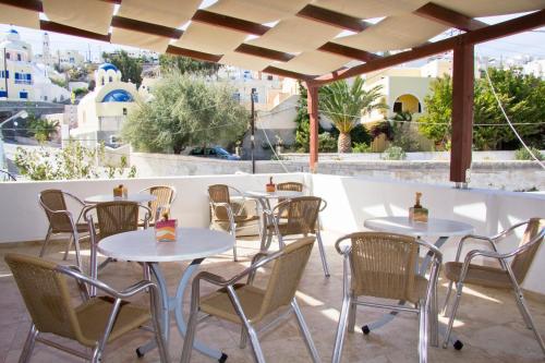 a dining room table with chairs and umbrellas at Sea of Aegeon in Fira