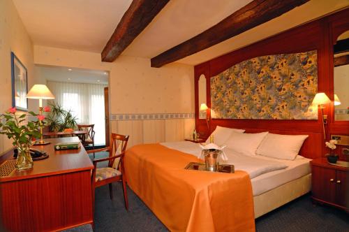 a hotel room with a bed and a desk at Landhotel Repetal in Attendorn