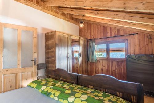 a bedroom with a bed and a window at Baita Pizabornè in Groppe de Fora
