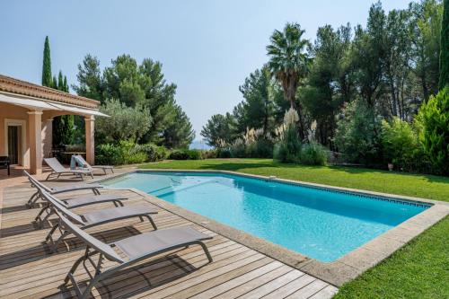- une piscine avec chaises longues sur une terrasse en bois dans l'établissement Villa Eléonore, à Saint-Cyr-sur-Mer