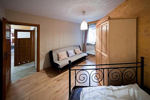 1 dormitorio con 1 cama y 1 sofá en una habitación en Apartments Zakopane Center, en Zakopane