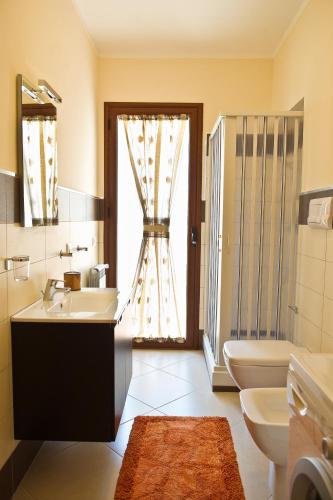 a bathroom with a sink and a toilet and a window at Bono Vacanze Villa San Marco Luxury Holidays Homes in Sciacca