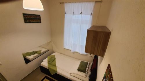 a small room with a bed and a window at Elisabeth Hostel in Vienna