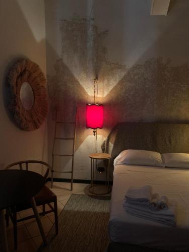een slaapkamer met een bed en een roze lamp bij Mood-Garibaldi in Pavia